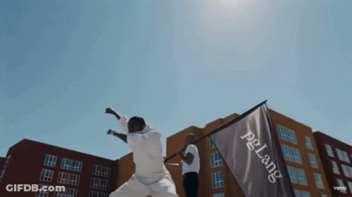 A Man Holds A Flag That Says Pelang On It GIF