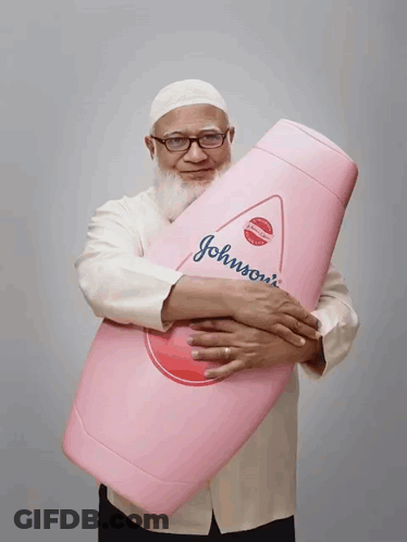 A Man Holds A Large Pink Bottle Of Johnson 'S Baby Shampoo GIF