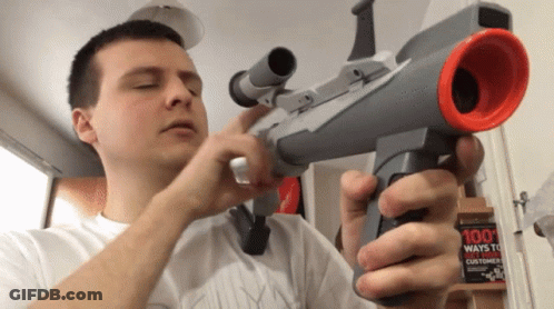 A Man Holds A Toy Gun In Front Of A 100 Ways To Win Customers Book GIF