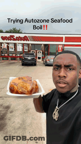 A Man Holds A Tray Of Food In Front Of A Smosh Shop GIF