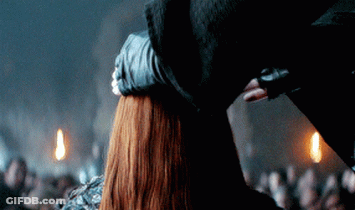 A Man Holds A Woman 'S Head In A Dark Room GIF