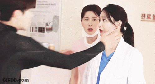 A Man Holds A Woman 'S Neck While A Nurse Looks On GIF