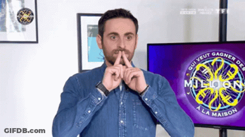 A Man Holds His Finger To His Mouth In Front Of A Tv Screen That Says Million A La Maison GIF