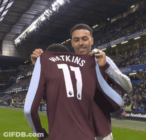 A Man Holds Up A Jersey That Says Watkins 11 GIF