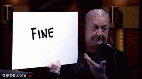 A Man Holds Up A Sign That Says Fine On It GIF