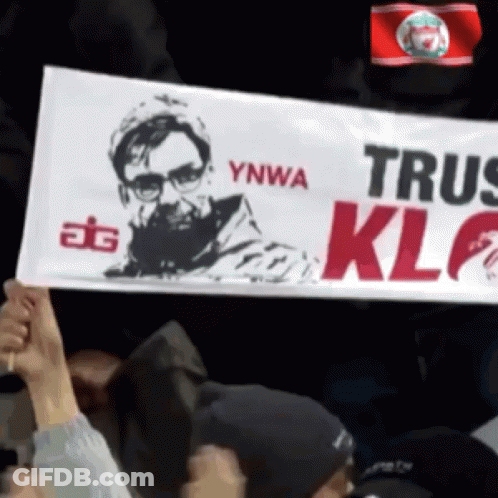 A Man Holds Up A Sign That Says Ynwa Trus Klf GIF