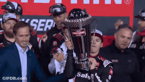 A Man Holds Up A Trophy That Says Safe On It GIF