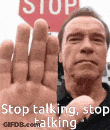 A Man Holds Up His Hand In Front Of A Red Stop Sign GIF