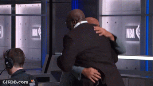 A Man Hugging Another Man In Front Of A Sign That Says Nba GIF