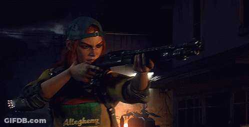 A Man In A Allegheny Shirt Is Holding A Gun GIF