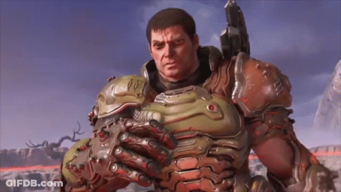 A Man In A Armored Suit Is Holding A Gun And Looking At The Camera . GIF