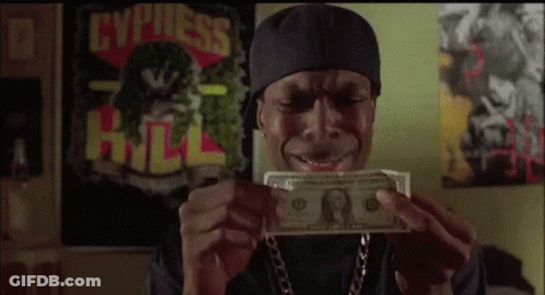A Man In A Bandana Is Holding A Dollar Bill In His Hands . GIF