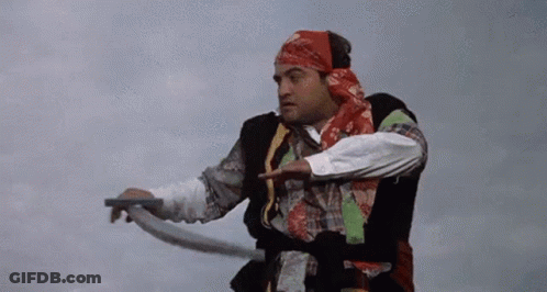 A Man In A Bandana Is Holding A Rope And Pointing At Something . GIF