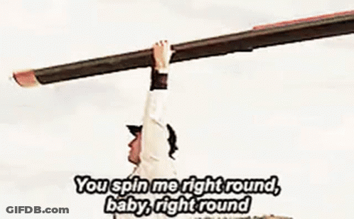 A Man In A Baseball Cap Is Holding His Arms Up In The Air While Singing A Song . GIF
