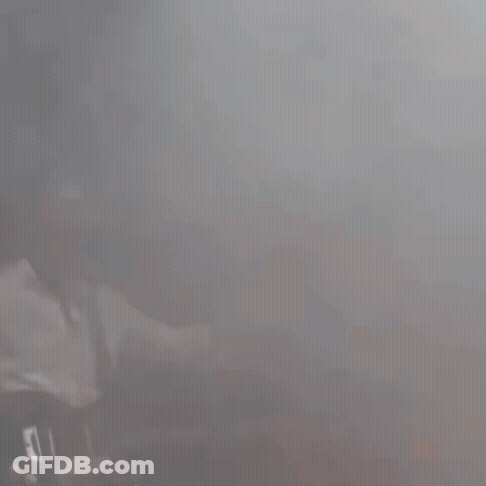 A Man In A Baseball Cap Is Playing A Guitar On Stage GIF