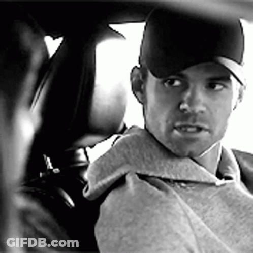 A Man In A Baseball Cap Is Sitting In A Car . GIF
