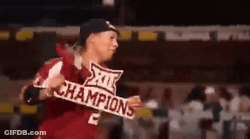 A Man In A Baseball Uniform Is Holding A Sign That Says Champions . GIF