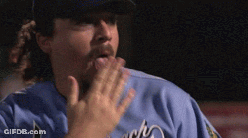A Man In A Baseball Uniform Is Making A Funny Face With His Hand . GIF