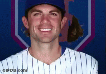 A Man In A Baseball Uniform Is Smiling In Front Of A Blue And Purple Background GIF