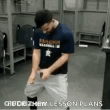 A Man In A Baseball Uniform Is Standing In A Locker Room With His Hands On His Hips . GIF