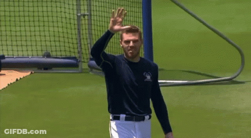 A Man In A Baseball Uniform Is Waving His Hand In The Air GIF