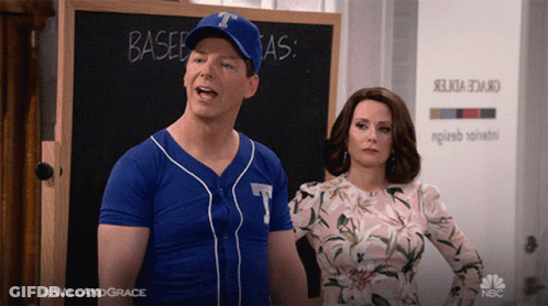 A Man In A Baseball Uniform Stands Next To A Woman In A Floral Dress GIF