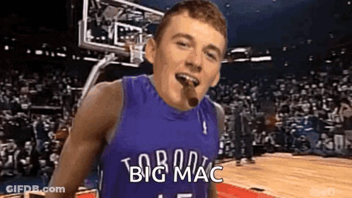 A Man In A Basketball Jersey Is Smoking A Cigar On A Basketball Court . GIF