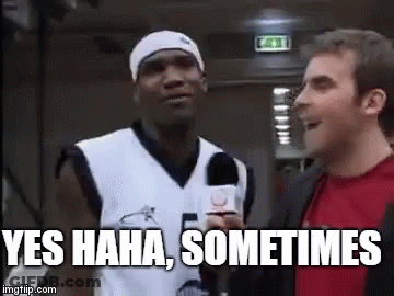 A Man In A Basketball Jersey Is Talking To A Man In A Red Shirt While Holding A Microphone . GIF