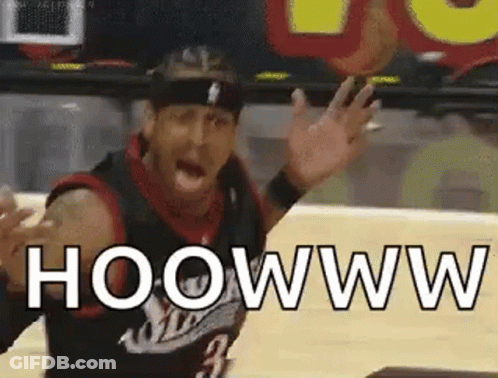 A Man In A Basketball Uniform Is Waving His Hands In The Air While Playing Basketball . GIF