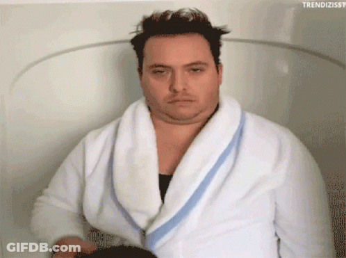 A Man In A Bathrobe Is Sitting In A Bathtub With The Hashtag Trendizisst GIF