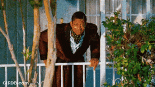 A Man In A Bathrobe Leans Over A Railing GIF