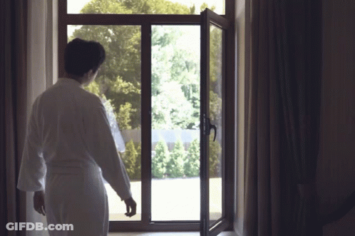 Man In Bathrobe Looking Out Window GIF