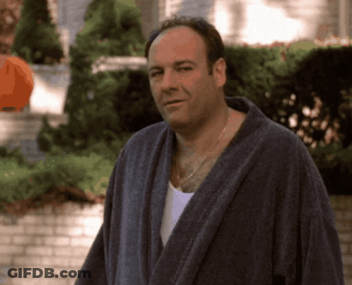 A Man In A Bathrobe Stands In Front Of A House GIF