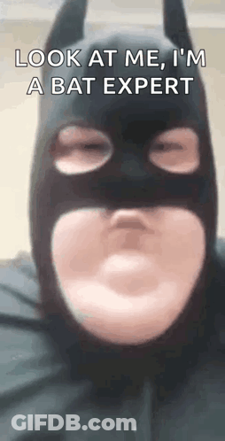 A Man In A Batman Costume Is Making A Funny Face . GIF