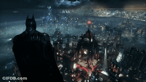 A Man In A Batman Costume Stands In Front Of A City GIF