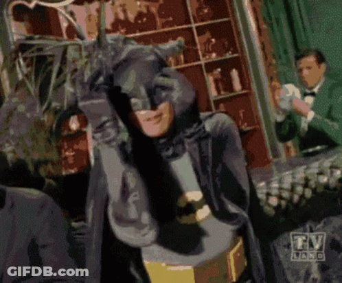 A Man In A Batman Costume Stands In Front Of A Tv Land Logo GIF