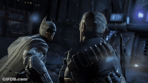 A Man In A Batman Costume Talks To Another Man GIF