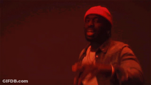 A Man In A Beanie And Leather Jacket Is Dancing GIF