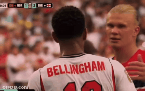 A Man In A Bellingham Jersey Talks To Another Man GIF