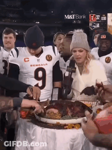 A Man In A Bengals Jersey Cuts A Turkey GIF