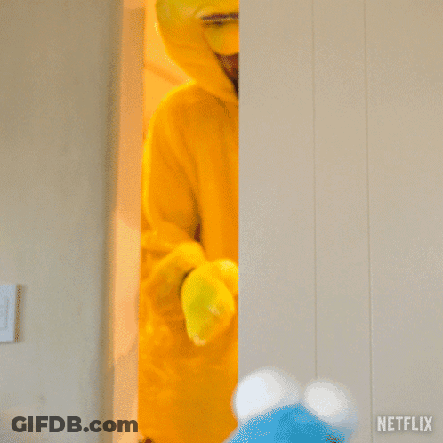 A Man In A Big Bird Costume Is Standing Next To A Netflix Sign GIF