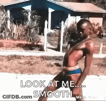 A Man In A Bikini Is Walking Down A Sidewalk With The Words `` Look At Me Smooth '' Written On It . GIF