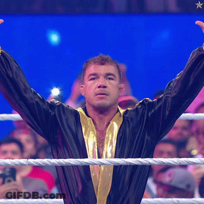 A Man In A Black And Gold Robe Stands In A Boxing Ring GIF