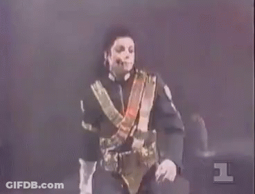 A Man In A Black And Gold Uniform Is Standing In Front Of A Red Background With The Number 1 On It GIF