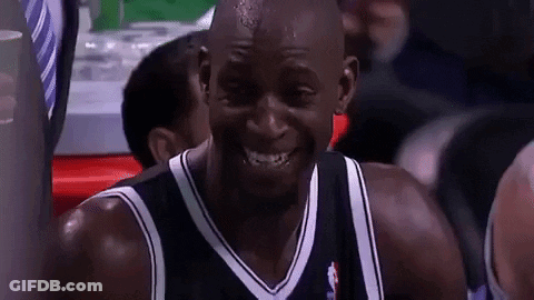 A Man In A Black And White Jersey Is Smiling GIF