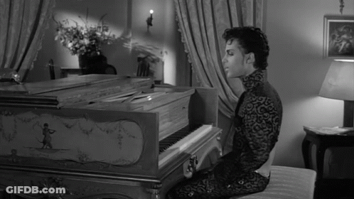 A Man In A Black And White Photo Is Playing A Piano GIF