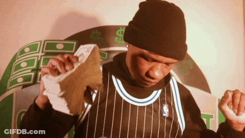 A Man In A Black And White Striped Jersey Holds Up A Stack Of Money GIF