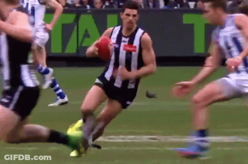 A Man In A Black And White Striped Shirt Is Running With A Red Ball GIF