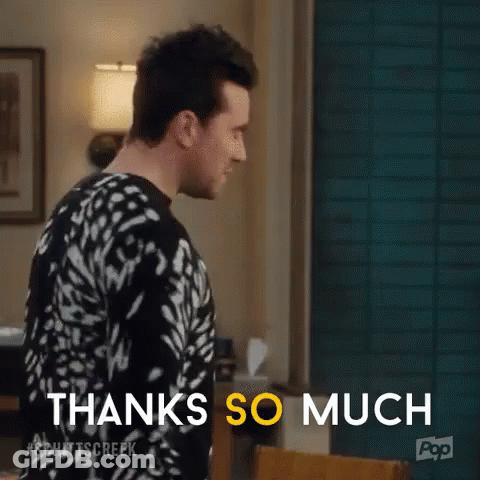 A Man In A Black And White Sweater Is Standing In A Living Room . GIF