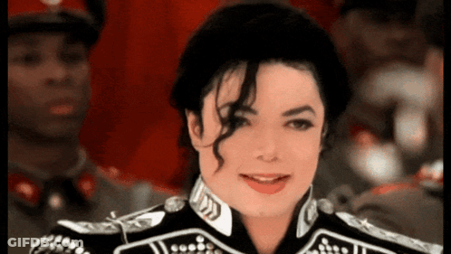 A Man In A Black And White Uniform Is Smiling For The Camera GIF